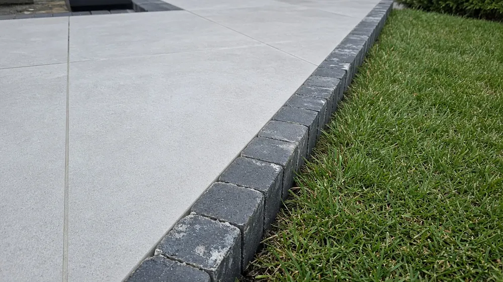 Example image: the edge of a porcelain patio with a block edging course